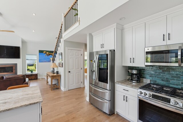 29 Bay Field Dr, Woolwich, ME 04579 - kitchen featuring appliances with stainless steel finishes, open floor plan, tasteful backsplash, recessed lighting, and white cabinetry