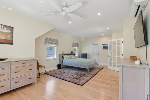 29 Bay Field Dr, Woolwich, ME 04579 - bedroom featuring light wood finished floors, an AC wall unit, recessed lighting, french doors, and a ceiling fan