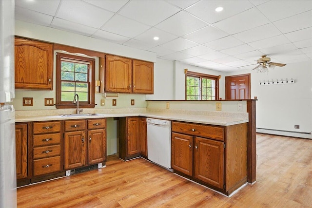 32 Skillings Corner Rd, Auburn, ME 04210 - kitchen featuring white dishwasher, a sink, a baseboard radiator, brown cabinetry, and a peninsula