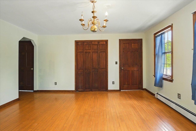 32 Skillings Corner Rd, Auburn, ME 04210 - unfurnished bedroom featuring a baseboard heating unit, a chandelier, a closet, and light wood-type flooring
