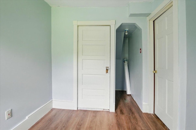 32 Skillings Corner Rd, Auburn, ME 04210 - unfurnished bedroom with wood finished floors, baseboards, and arched walkways