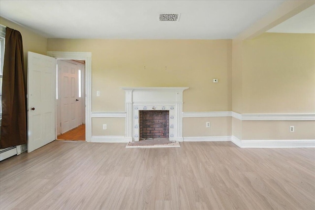 32 Skillings Corner Rd, Auburn, ME 04210 - unfurnished living room with light wood-style flooring, a fireplace with raised hearth, and baseboards