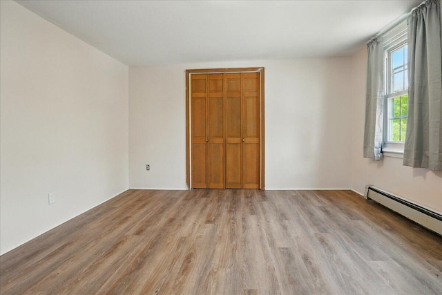 32 Skillings Corner Rd, Auburn, ME 04210 - unfurnished bedroom featuring a baseboard radiator, light wood-style floors, and a closet