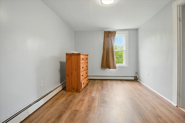 32 Skillings Corner Rd, Auburn, ME 04210 - unfurnished bedroom featuring baseboard heating, wood finished floors, and baseboards