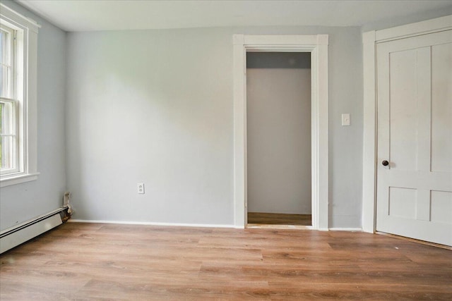 32 Skillings Corner Rd, Auburn, ME 04210 - unfurnished bedroom with baseboard heating, light wood-style floors, and baseboards