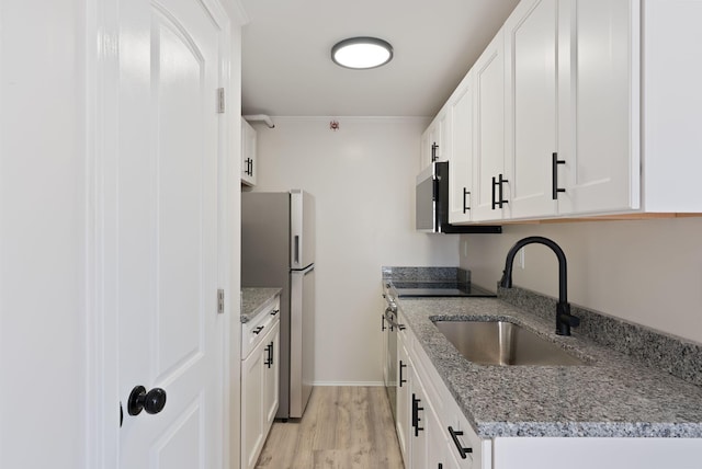 5 Kinney Ave Unit 302, Old Orchard Beach, ME 04064 - kitchen featuring freestanding refrigerator, a sink, range, light wood finished floors, and white cabinets