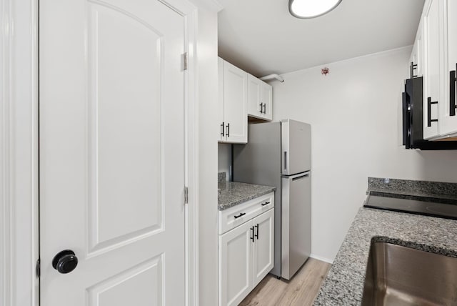 5 Kinney Ave Unit 302, Old Orchard Beach, ME 04064 - kitchen with freestanding refrigerator, white cabinets, light wood finished floors, a sink, and light stone counters