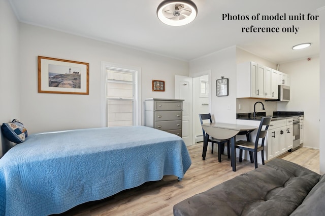 5 Kinney Ave Unit 302, Old Orchard Beach, ME 04064 - bedroom featuring light wood-style flooring, a sink, ornamental molding, and a baseboard radiator