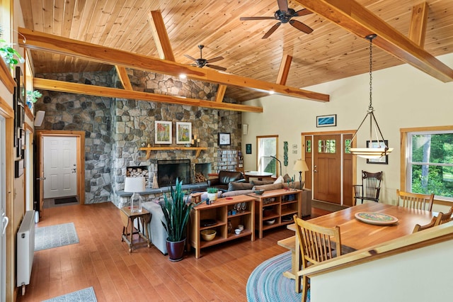 21 Jones Dr, Hartford, ME 04220 - living area with ceiling fan, a stone fireplace, a wooden ceiling with exposed beams, wood-type flooring, and radiator heating unit