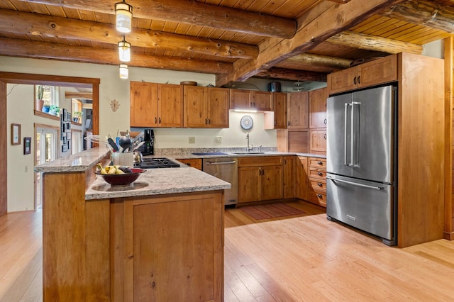 21 Jones Dr, Hartford, ME 04220 - kitchen with stainless steel appliances, a wooden ceiling with exposed beams, light wood-type flooring, brown cabinets, and a peninsula