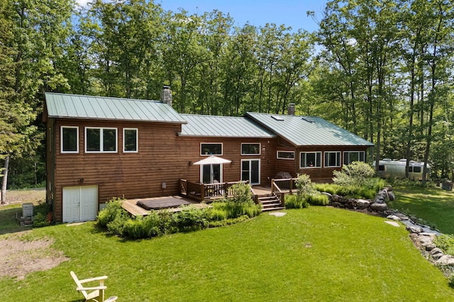 21 Jones Dr, Hartford, ME 04220 - rear view of property featuring a chimney, a yard, a standing seam roof, a wooden deck, and a metal roof
