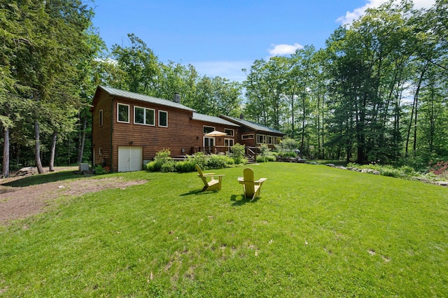 21 Jones Dr, Hartford, ME 04220 - view of front of home with dirt driveway, a front lawn, a wooden deck, and a metal roof