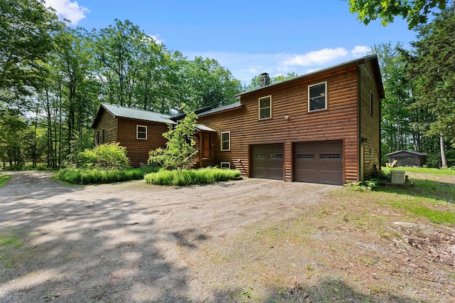 21 Jones Dr, Hartford, ME 04220 - chalet / cabin with dirt driveway, a garage, a chimney, and faux log siding