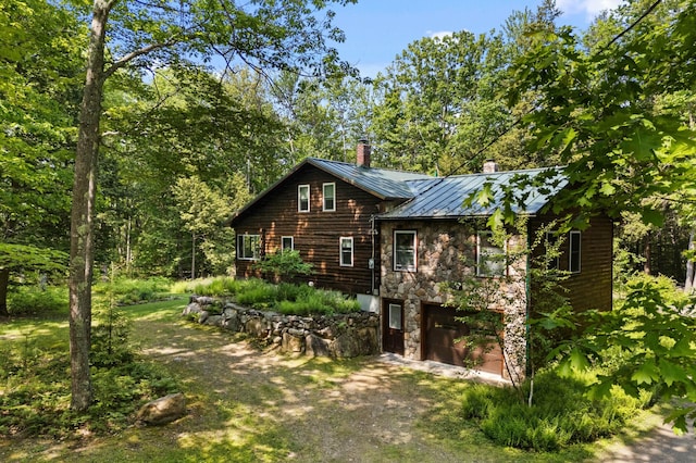 21 Jones Dr, Hartford, ME 04220 - view of property exterior with a standing seam roof, a chimney, stone siding, driveway, and a metal roof