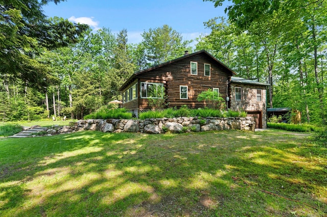 21 Jones Dr, Hartford, ME 04220 - view of side of property with a lawn, a garage, a chimney, and log siding