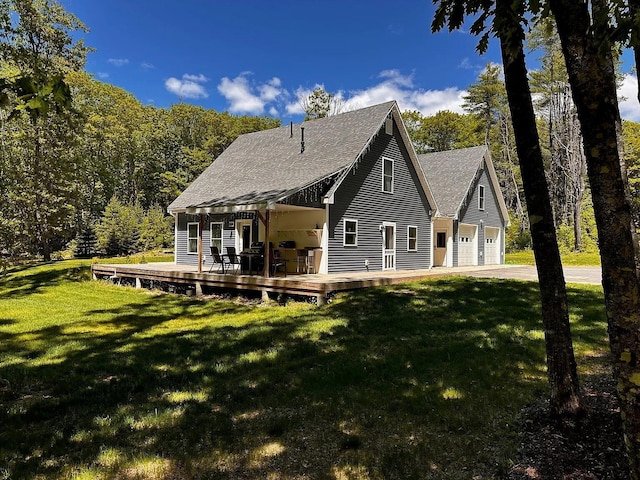 9 Springer Ln, Morrill, ME 04952 - back of property with a deck, a garage, a shingled roof, and a lawn