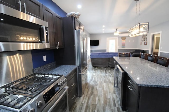 9 Springer Ln, Morrill, ME 04952 - kitchen featuring appliances with stainless steel finishes, open floor plan, light wood-type flooring, stone countertops, and ceiling fan