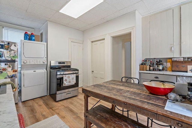 130 Emery St, Portland, ME 04102 - kitchen featuring stainless steel range with gas stovetop, stacked washer / drying machine, freestanding refrigerator, and light countertops