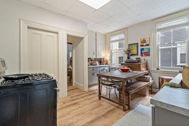 130 Emery St, Portland, ME 04102 - kitchen featuring black gas stove, light wood-type flooring, light countertops, and a drop ceiling