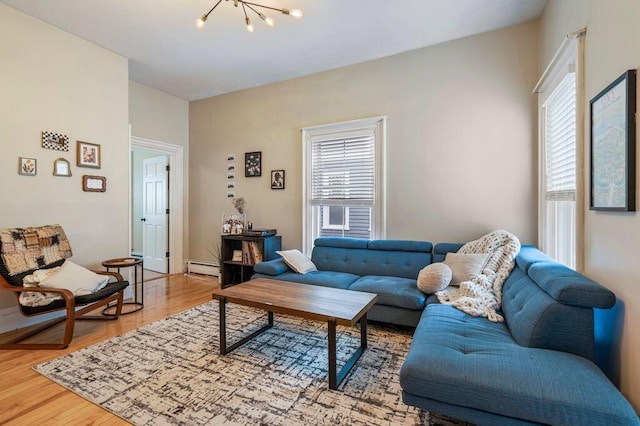 130 Emery St, Portland, ME 04102 - living area with a chandelier, light wood-type flooring, and a baseboard heating unit