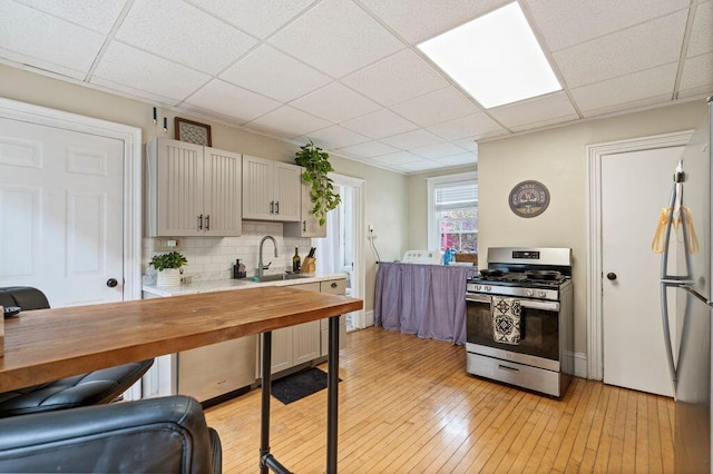 130 Emery St, Portland, ME 04102 - kitchen featuring stainless steel range with gas stovetop, tasteful backsplash, light wood-style flooring, butcher block counters, and a paneled ceiling
