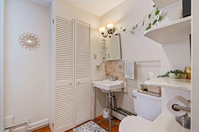 130 Emery St, Portland, ME 04102 - bathroom featuring a closet, wood finished floors, decorative backsplash, and a baseboard radiator