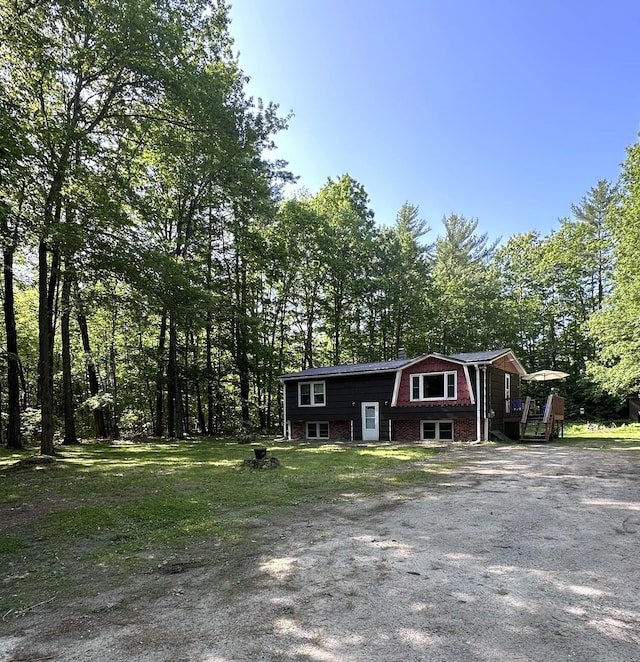 15 Balsam Ln, Naples, ME 04055 - view of front facade with brick siding, a wooden deck, and a gambrel roof