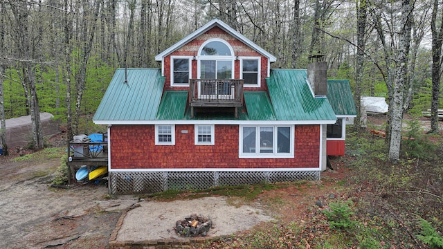 110 Indian Point Dr, Denmark, ME 04022 - view of property exterior with a balcony, a fire pit, metal roof, and a chimney