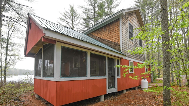 110 Indian Point Dr, Denmark, ME 04022 - view of home's exterior with a sunroom, metal roof, and a water view