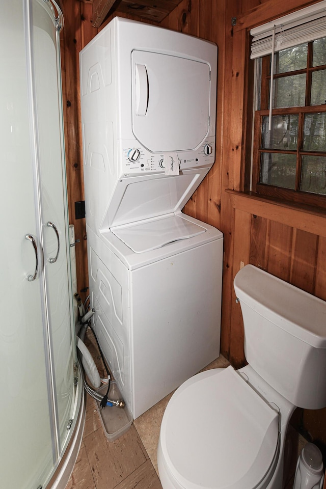 110 Indian Point Dr, Denmark, ME 04022 - bathroom featuring stacked washer / dryer, a shower stall, wood walls, and toilet