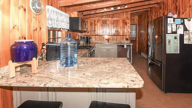 110 Indian Point Dr, Denmark, ME 04022 - kitchen with appliances with stainless steel finishes, wooden walls, a sink, light stone counters, and a peninsula