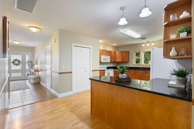 8 Kavanaugh Rd Unit 8, Old Orchard Beach, ME 04064 - kitchen featuring white appliances, a peninsula, brown cabinets, decorative light fixtures, and light wood-style flooring