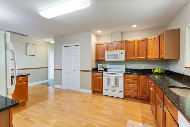 8 Kavanaugh Rd Unit 8, Old Orchard Beach, ME 04064 - kitchen featuring white appliances, light wood-style flooring, brown cabinetry, recessed lighting, and dark stone countertops