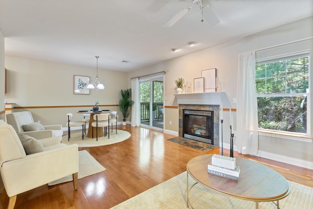 8 Kavanaugh Rd Unit 8, Old Orchard Beach, ME 04064 - living area featuring a fireplace, wood finished floors, a ceiling fan, and a chandelier