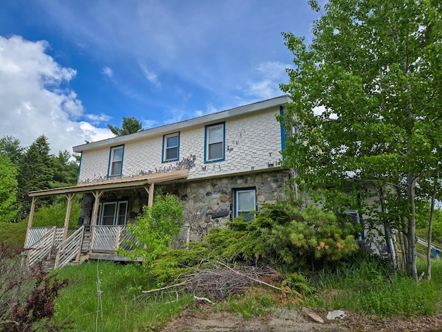 291 Pea Ridge Rd, Chester, ME 04457 - back of house with stone siding and a porch