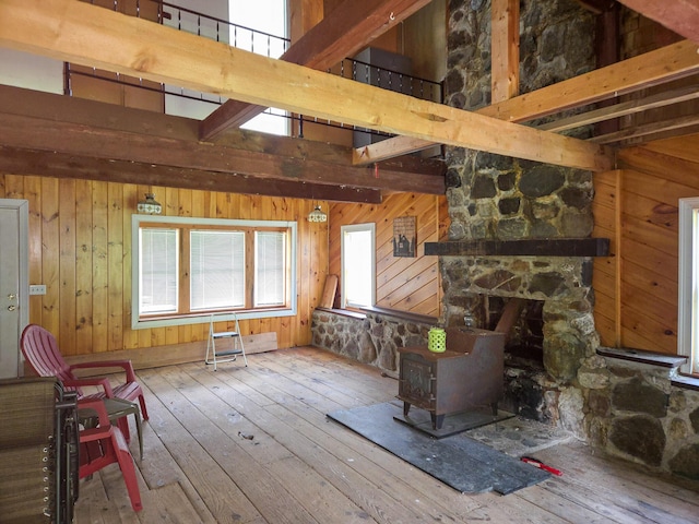 291 Pea Ridge Rd, Chester, ME 04457 - living area with wood-type flooring, a wood stove, wood walls, and beam ceiling