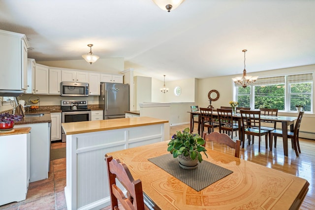 30 Date St, Old Orchard Beach, ME 04064 - dining space with a chandelier, baseboards, lofted ceiling, and light wood-style floors