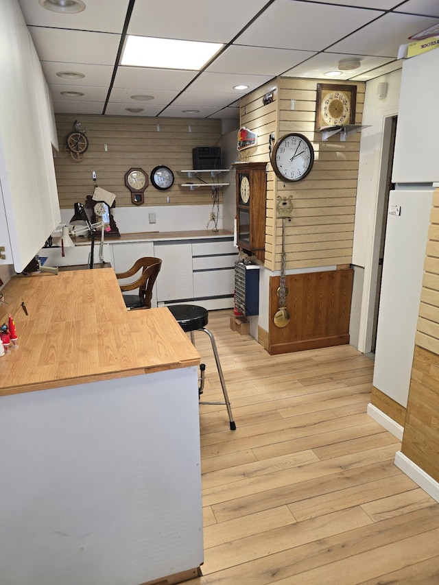 30 Date St, Old Orchard Beach, ME 04064 - kitchen featuring wood walls, a drop ceiling, light wood-style floors, baseboards, and butcher block counters