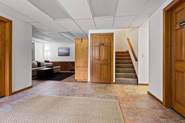 2 Flynn Rd, Raymond, ME 04071 - hall featuring a drop ceiling, stairs, tile patterned floors, and baseboards