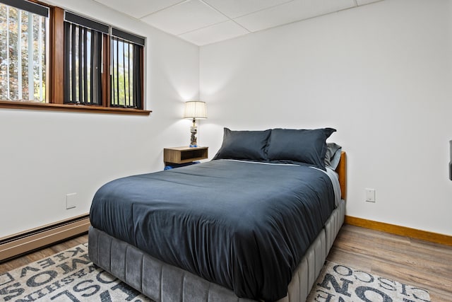 2 Flynn Rd, Raymond, ME 04071 - bedroom with baseboards, wood finished floors, a baseboard radiator, and a drop ceiling