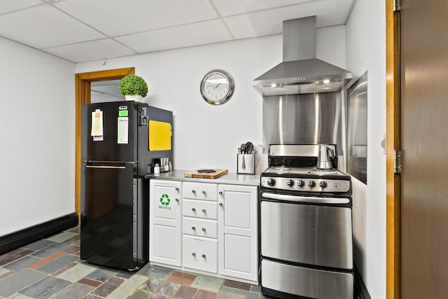2 Flynn Rd, Raymond, ME 04071 - kitchen featuring wall chimney range hood, stainless steel range with gas stovetop, freestanding refrigerator, a drop ceiling, and white cabinetry