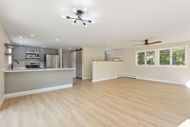 142 Hacker Rd, Brunswick, ME 04011 - unfurnished living room with a barn door, a baseboard heating unit, a chandelier, recessed lighting, and light wood-style flooring