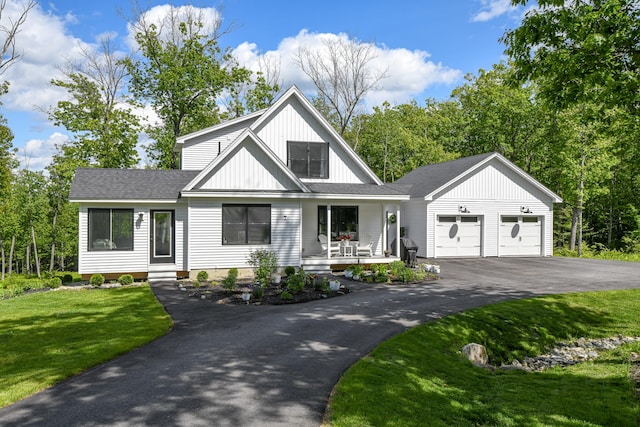7 Elysian Way, Bridgton, ME 04009 - modern farmhouse featuring driveway, a garage, covered porch, a front lawn, and board and batten siding