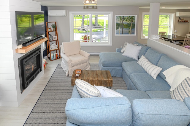 7 Elysian Way, Bridgton, ME 04009 - living area featuring a wall mounted air conditioner, light wood-style floors, and a large fireplace