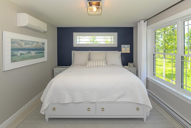 7 Elysian Way, Bridgton, ME 04009 - bedroom featuring a wall mounted air conditioner, baseboard heating, baseboards, and light wood-style flooring
