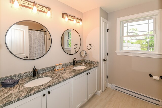 7 Elysian Way, Bridgton, ME 04009 - full bathroom featuring a baseboard radiator, double vanity, baseboards, and wood finished floors