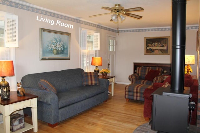 225 Webber Ave, Lewiston, ME 04240 - living room with wood finished floors, ceiling fan, ornamental molding, and a wood stove