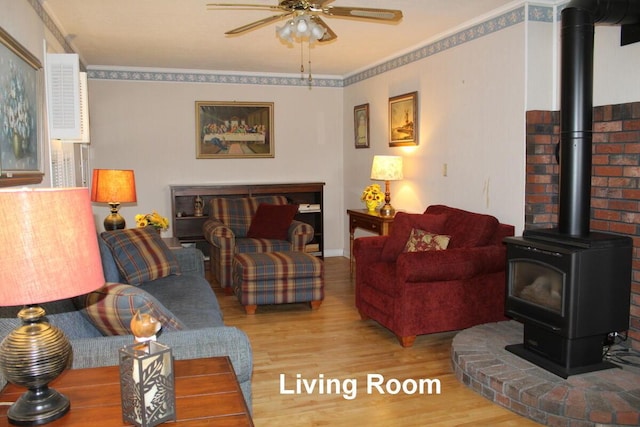 225 Webber Ave, Lewiston, ME 04240 - living area featuring a wood stove, wood finished floors, ceiling fan, and ornamental molding