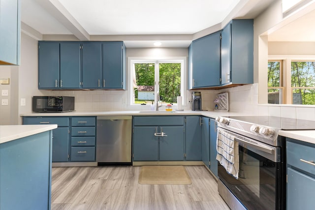 71 Blake Rd, Turner, ME 04282 - kitchen with appliances with stainless steel finishes, a sink, blue cabinetry, and light wood-type flooring