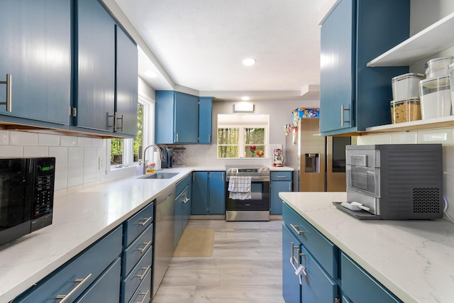 71 Blake Rd, Turner, ME 04282 - kitchen featuring stainless steel appliances, blue cabinets, a sink, open shelves, and decorative backsplash